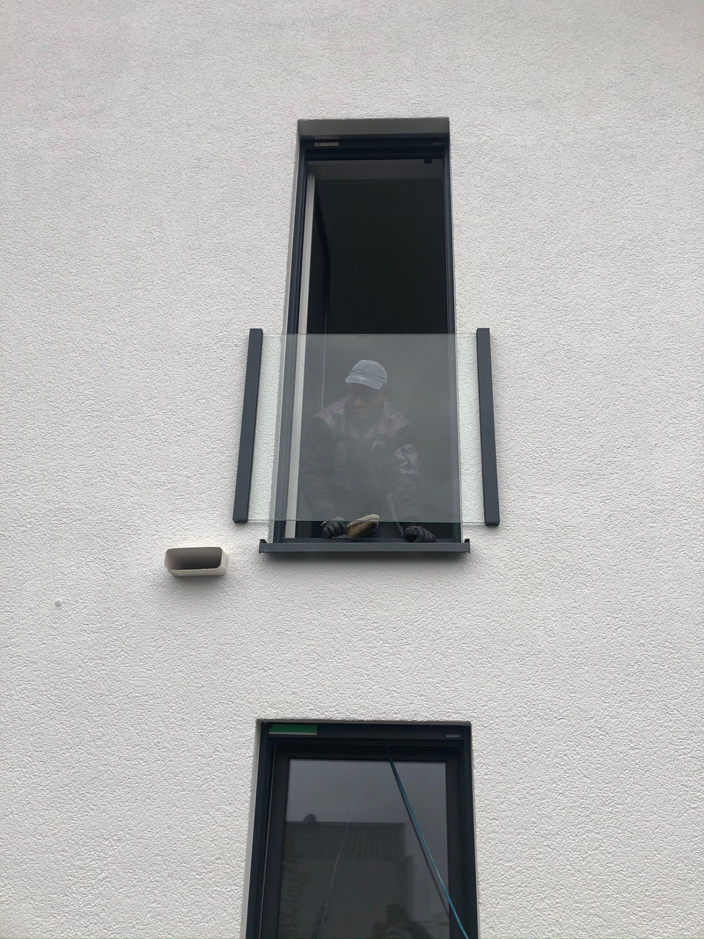 Montage einer Glasbrüstung als Absturzsicherung vor einem bodentiefen Fenster