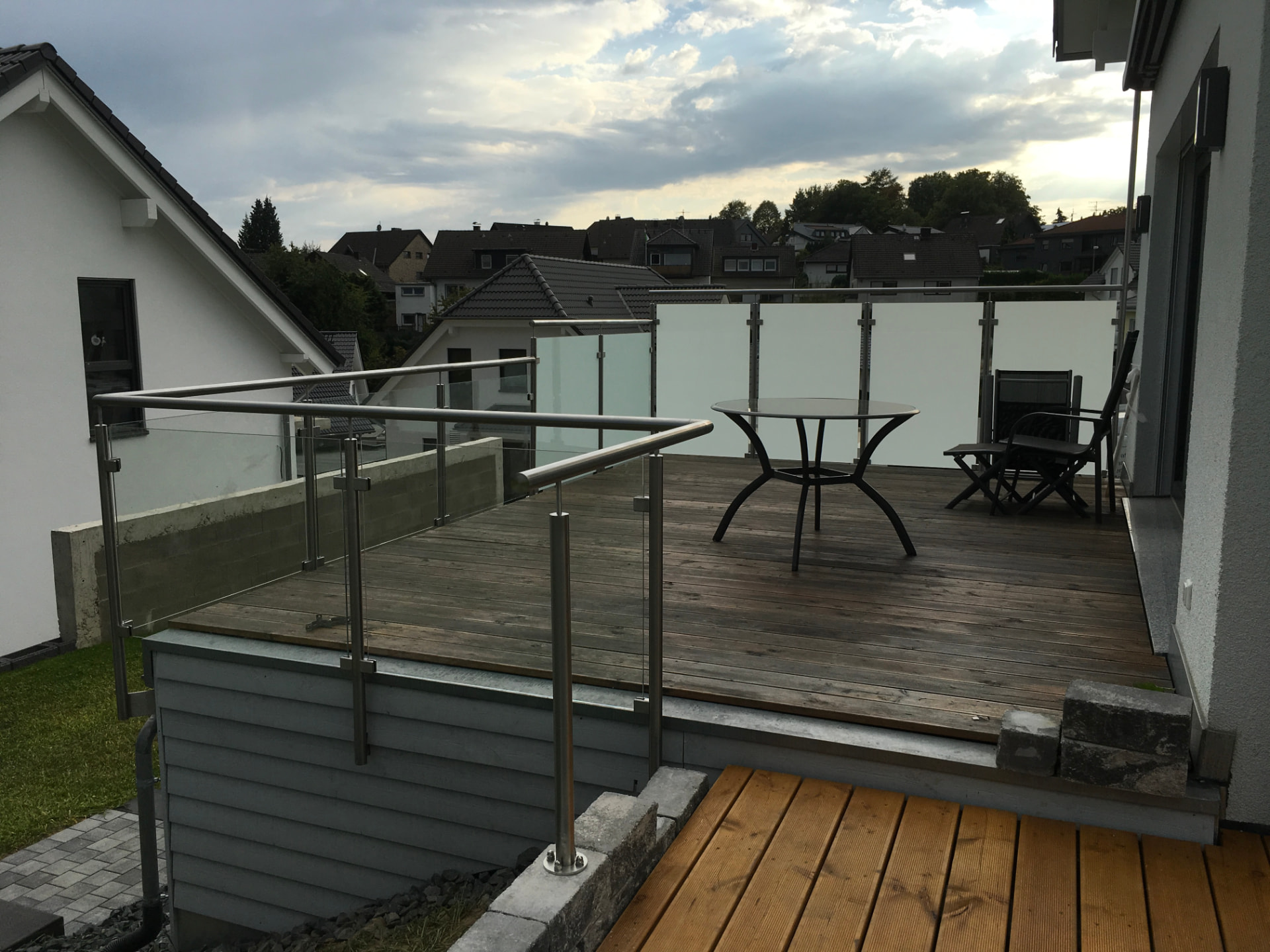 Edelstahlgeländer mit Glasklemmen auf einer Holzterrasse