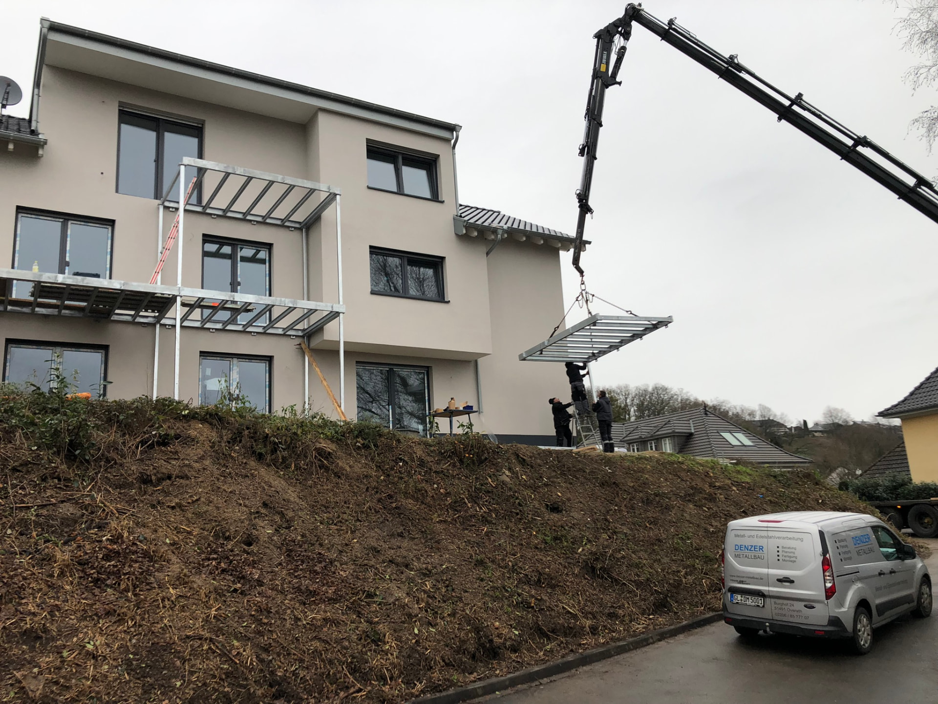 Vorgefertigte Balkonkonstruktion wird per Ladekran an einen Neubau montiert